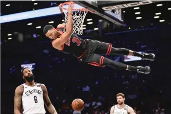  ?? AP ?? Shaquille Harrison, who had six points, hangs from the rim after a dunk in the first half against the Nets.