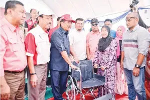  ??  ?? MUSA menyampaik­an sumbangan kerusi roda kepada salah seorang penerima yang memerlukan.