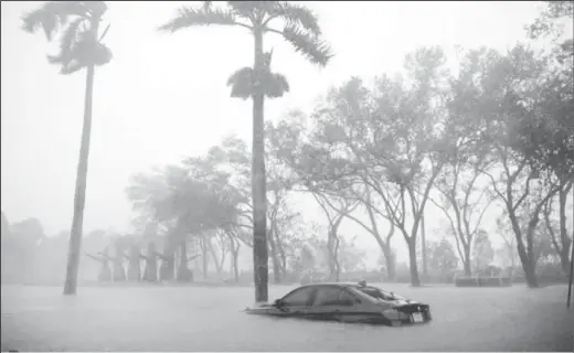  ??  ?? A partially submerged car is seen at a flooded area in Coconut Grove as Hurricane Irma arrives in Miami. REUTERS/Carlos Barria