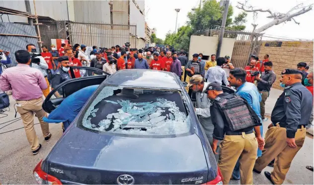  ?? Reuters ?? ↑
Police inspect a damaged car at the site of an attack at the Pakistan Stock Exchange entrance in Karachi on Monday.