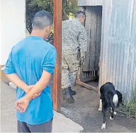  ??  ?? Final. De celeste, el detenido, mientras la Policía revisa su casa.