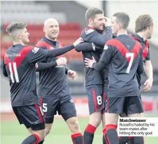  ??  ?? Matchwinne­r Russell is hailed by his team-mates after hitting the only goal