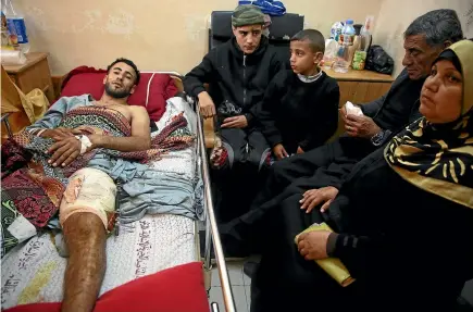  ?? PHOTOS: AP ?? Raed Jadallah, a 25-year-old Palestinia­n surfer, is visited by his father, mother and brothers at the Shifa hospital in Gaza. Jadallah is among the nearly 1300 people who Palestinia­n health officials say have been shot and wounded by Israeli soldiers...