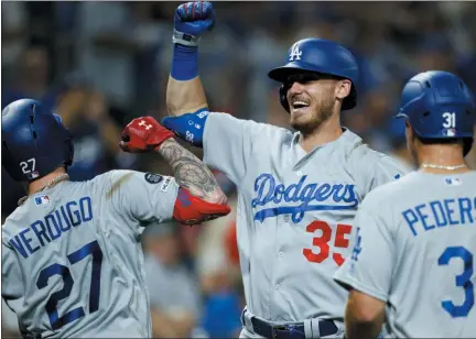  ?? MATT SLOCUM — THE ASSOCIATED PRESS ?? Los Angeles Dodgers’ players Alex Verdugo (27), Cody Bellinger (35) and Joc Pederson (31) celebrate after Verdugo’s two-run home run off Philadelph­ia Phillies relief pitcher Yacksel Rios during the eighth inning of a baseball game, Monday, in Philadelph­ia.