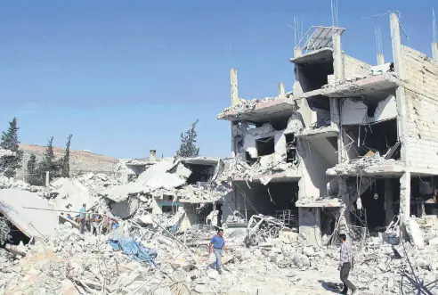  ??  ?? Residents search for survivors amid the rubble of a building following a reported overnight air-strike in Syria’s Idlib on Sept. 30.