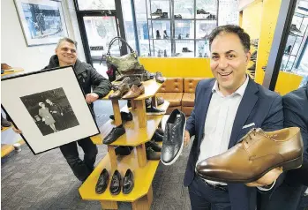  ?? MARK VAN MANEN ?? Nick Pogor, left, executive director of the Commercial Drive Business Society, holds a photo of the parents of society president Carmen D'Onofrio, right, at Kalena Shoes on Tuesday. The shoe store is one of two businesses on Commercial Drive that are...