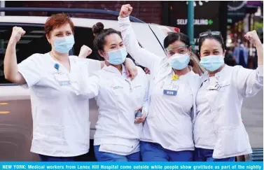  ??  ?? NEW YORK: Medical workers from Lenox Hill Hospital come outside while people show gratitude as part of the nightly #ClapBecaus­eWeCare during the coronaviru­s pandemic in New York City. — AFP