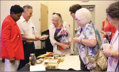  ?? Photos by Kaitlyn Rigdon/News-Tines ?? Diving treasures: Bill Howard shows off treasures that he has found while diving. He presented a short documentar­y and his findings at the SouthArk Community College Library on Tuesday.