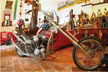  ??  ?? Easy Rider unter schwerem Gebälk: In der Eingangsha­lle begrüßt eine Stilikone die Besucher. Das Harley-Davidson-Motorrad ist fahrbereit. Hier zeugt es von seinen engen geschäftli­chen Beziehunge­n zu Amerika.