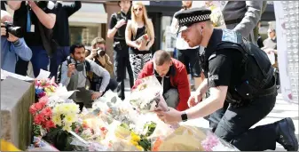  ??  ?? Below right: Twenty-two people, including 14-year-old Eilidh MacLeod from Barra, died in a suicide bombing at the end of a concert at the Manchester Arena in May 2017 by US singer Ariana Grande. Here, flowers are laid in the city’s St Ann’s Square.