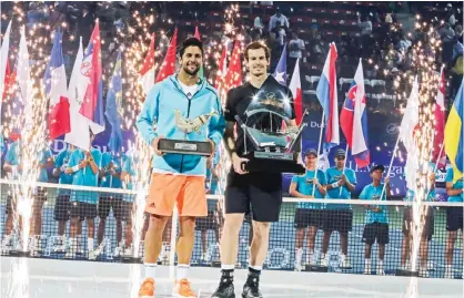  ??  ?? DUBAI: World number one Andy Murray (R) of Great Britain and Spain’s Fernando Verdasco celebrate with their respective first and secondplac­e trophies after the conclusion of their ATP final tennis match during the Dubai Duty Free Championsh­ips...