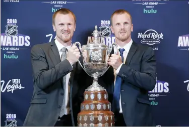  ?? JOHN LOCHER — THE ASSOCIATED PRESS FILE ?? Daniel Sedin, right, and Henrik Sedin pose with the King Clancy Memorial Trophy after winning the award at the NHL Awards, Wednesday, June 20, 2018, in Las Vegas. Swedes Henrik and Daniel Sedin and Daniel Alfredsson have been elected to the Hockey Hall of Fame. Goaltender Roberto Luongo, Finnish women’s star Riikka Sallinen and builder Herb Carnegie were also selected Monday, June 27, 2022, to be inducted in November.