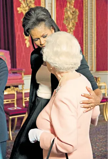  ??  ?? Michelle Obama had no idea of the criticism that would follow her arm around the Queen, above. Left, on the cover of Elle magazine