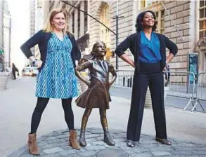  ?? AP ?? Two women pose with the Fearless Girl statue. The artwork went up early this month and immediatel­y became a tourist draw and internet sensation.