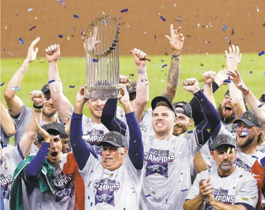  ?? KEVIN M. COX/GALVESTON COUNTY DAILY NEWS VIA AP ?? Manager Brian Snitker and the Braves celebrate with the World Series trophy on Tuesday.