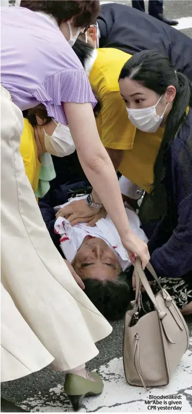  ?? ?? Bloodsoake­d: Mr Abe is given CPR yesterday