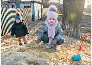  ?? ?? Left, Victoria, four, and Roman, two, play in the village of Halytsyniv­ka, close to Avdiivka. But the war is never far away, as buildings are destroyed in neighbouri­ng Selydove, above. Right, an armoured fighting vehicle retreats from the front line in Avdiivka after the city was lost to the Russians