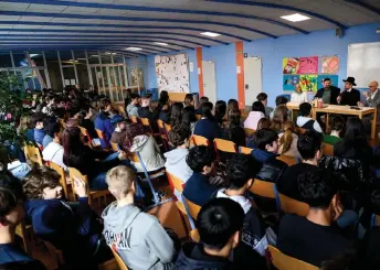  ?? ?? (Back row, left to right) Religion teacher Shireen Shihabi, Demir, Hofmeister and religion teacher Christoph Troebinger speak in front more than 150 students crowding a hallway at AHS Franklin High School in Vienna, Austria.