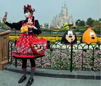  ??  ?? In Cina
Una giovane donna vestita da Minnie si fa un selfie all’interno dl Disneyland Shanghai
