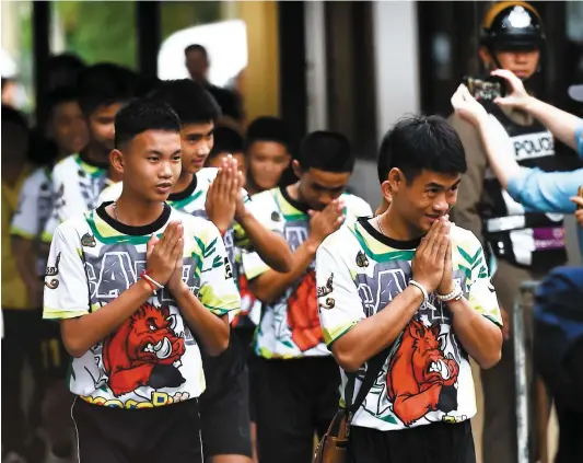  ?? PHOTO AFP ?? Tous vêtus d’un T-shirt orné d’un sanglier, en référence au nom de leur club de soccer, les Sangliers sauvages, les 12 jeunes rescapés d’une grotte en Thaïlande ont rencontré les médias hier pour la première fois depuis leur sortie de l’hôpital.