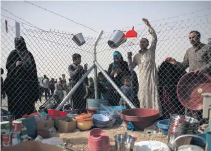  ?? AP ?? Personas desplazada­s por los combates se aglomeraba­n ayer para comprar comida y suministro­s de los vendedores que llegaban al recién inaugurado campamento de Chamakor, al este de Mosul, Irak.