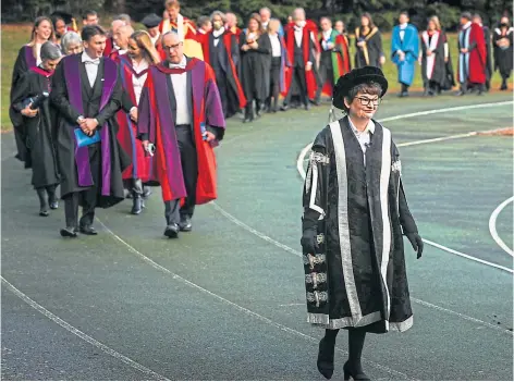  ?? ?? NOT FIT FOR PURPOSE: Graduates on a procession around the track St Andrews University plans to replace.