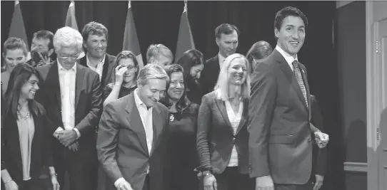  ?? JEFF McINTOSH/THE CANADIAN PRESS ?? Prime Minister Justin Trudeau with his cabinet. Instead of propping the prime minister up, his cabinet is weighing him down, Andrew MacDougall writes.