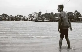  ?? Carlos Herrera / Associated Press ?? A boy looks over a flooded river after Hurricane Eta hitWawa, Nicaragua. Central and northern Nicaragua and much of Honduras could get 15 to 25 inches of rain, with 35 inches in some areas.