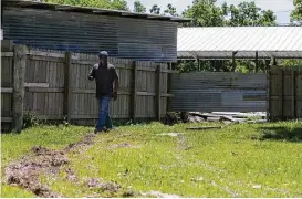  ?? Godofredo A. Vasquez / Houston Chronicle ?? Kendall Lewis follows the tire marks from a property fence to the graves of his second cousins and uncles, which were just missed by the person who drove through the Barrett Station Evergreen Cemetery.