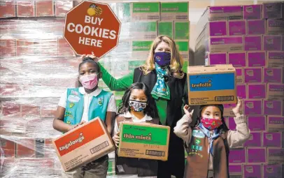  ?? Rachel Aston Las Vegas Review-journal @rookie__rae ?? From left, Girl Scouts Aliyah H., 9, Ariana H., 7, Kimberly Trueba, CEO of Girl Scouts of Southern Nevada, and Penelope W., 7, display boxes of Girl Scout cookies at the Bekins Moving Solutions warehouse.