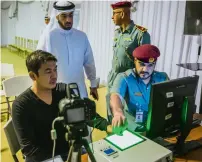  ??  ?? An officer taking biometrics of an amnesty-seeker.