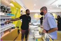  ?? NELVIN C. CEPEDA U-T FILE ?? Victor Ukpe (left) helps Mick Fryhoff select and purchase cannabis products at the Grasshoppe­r Dispensary.