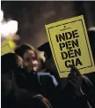  ?? PAU BARRENA/AFP/ GETTY IMAGES ?? A man holds a paper reading in Catalan “Independen­ce” in front of the Generalita­t Palace on Tuesday in Barcelona.