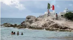  ?? Associated Press ?? ■ People spend time Saturday on the coast of Cancun, Mexico. An irony of the coronaviru­s pandemic is that the idyllic beach vacation in Mexico in the brochures really does exist now: the white sand beaches are sparkling clean and empty on the Caribbean coast.