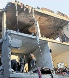  ?? /Reuters ?? Lost and found: Palestinia­n men inspect the damage at the site of Israeli strikes on houses, amid the conflict between Israel and the Palestinia­n Islamist group Hamas, in Rafah.