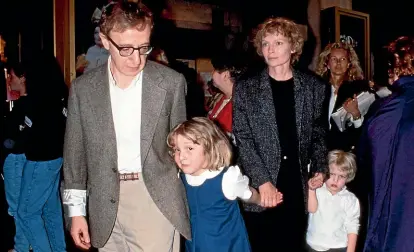  ?? GETTY IMAGES ?? Woody Allen steps out with adopted daughter Dylan Farrow, while Mia Farrow follows with son Satchel (now known as Ronan).