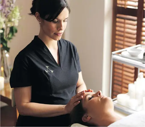  ??  ?? An Aromathera­py Associates practition­er expertly massages a client’s face, neck and shoulders during a facial session.