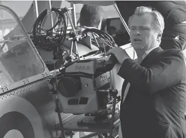  ?? PHOTOS BYMELINDA SUE GORDON, WARNER BROS. ?? Director Christophe­r Nolan readies an IMAX camera on a Spitfire to land the heartracin­g pilot’s- eye- view scenes in Dunkirk.