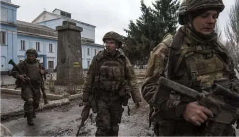  ?? ?? FILE PHOTO - Ukrainian servicemen who recently returned from the trenches of Bakhmut walk on a street in Chasiv Yar, Ukraine, Wednesday, March 8, 2023.