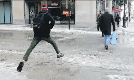  ?? ALLEN MCINNIS ?? A pedestrian takes a running leap over a puddle at the corner of Ste-Catherine and Metcalfe streets. The days of the Montreal jaywalker seem to be behind us, according to Josh Freed’s casual survey of intersecti­ons along Ste-Catherine on a particular­ly chilly day.