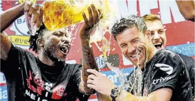  ?? Martin Meissner / AP ?? Xabi Alonso (derecha) celebra con sus jugadores el título de la Bundesliga certificad­o ayer en Leverkusen.