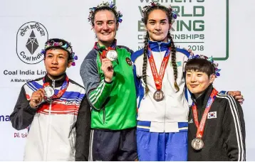  ??  ?? DELHI DELIGHT: Lightweigh­t champion Kellie Harrington shows off her gold alongside silver medallist Seesondee, left, and bronze winners Karina Ibragimova, second right, and Oh Yeonji