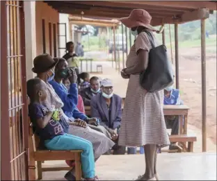  ??  ?? Village health worker Prisca Gwenzi (standing) shares Covid-19 informatio­n with villagers at a shopping centre in Chipinge