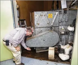  ?? LANNIS WATERS / THE PALM BEACH POST 2016 ?? Daniel Hughes, then the Palm Beach County School District’s facility management coordinato­r, checks a leaking air handler in the air-conditioni­ng system at Grove Park Elementary in Palm Beach Gardens in October 2016.