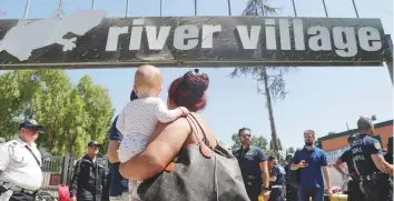  ?? AP ?? A woman holds a child after being evicted from the Camping River village, which housed a Roma camp, in Rome, yesterday.