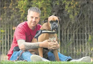 ?? JOSE CARLOS FAJARDO STAFF PHOTOGRAPH­ER ?? Veteran Clifford Waugaman, 34, of Tracy hugs his service dog, Django, 5, at Tony La Russa’s Animal Rescue Foundation in Walnut Creek. Waugaman returned home from service in the U.S. Navy with PTSD after spending eight months in Iraq in 2006.