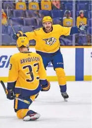  ?? ANDREW NELLES/THE TENNESSEAN VIA AP ?? Nashville Predators right wing Viktor Arvidsson (33) celebrates his goal against the Carolina Hurricanes with left wing Filip Forsberg (9) during the third period on Monday.