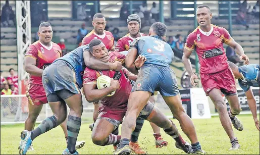  ?? Picture: REINAL CHAND ?? East Blues defenders work hard to stop West Maroons’ Savenaca Naovuka, with ball, during their match in the Fiji National Rugby League Pherrus Vanua State of Origin II at Prince Charles Park in Nadi yesterday.