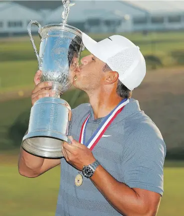  ?? — THE ASSOCIATED PRESS ?? Brooks Koepka has a kiss for the champion’s trophy after winning the U.S. Open for the second straight year Sunday in Southampto­n, N.Y.
