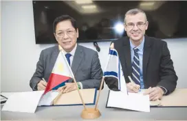  ?? (Oded Karni) ?? TOURISM MINISTER Yariv Levin (right) and Philippine­s Labor and Employment Minister Silvestre Bello sign a bilateral labor agreement yesterday.